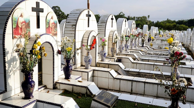 Op de openbare begraafplaats liggen identieke witte keramische graven met bloemen