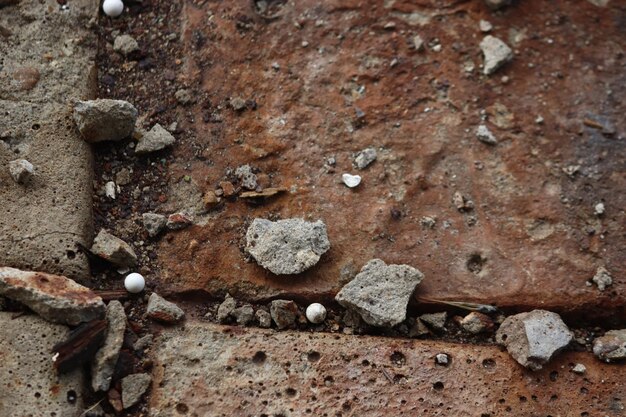 op de oude tegels op de grond roeststof en witte plastic airsoftballen