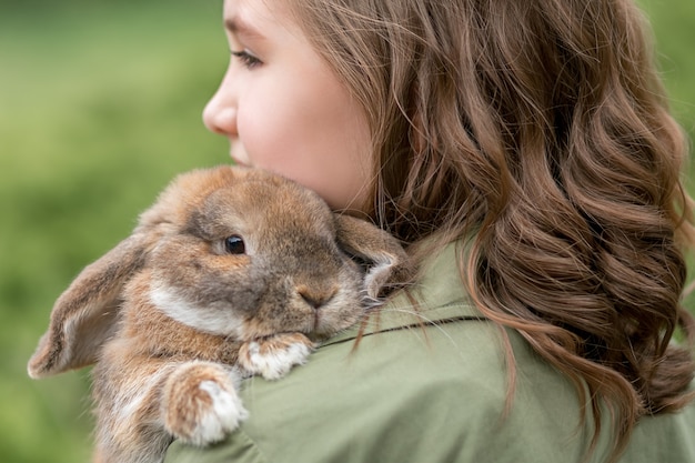 Op de schouder van het meisje ligt een schattig gemberkonijn