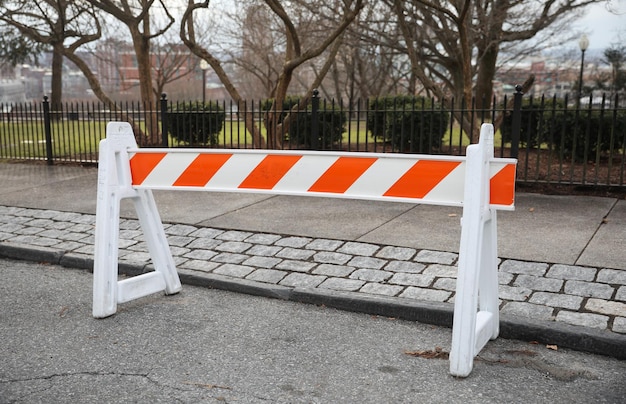 Op de stoep staat een wit met oranje barricade.