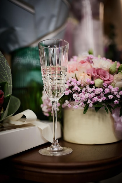 Op de tafel staan boeketten met bloemen en glazen champagne op de achtergrond van geschenken.