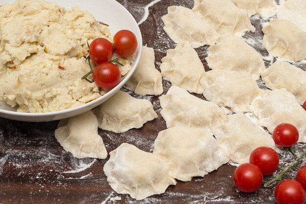 Op de tafel staat een bord met gekookte aardappelen en tomaten.