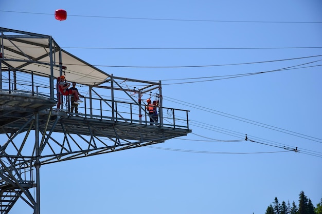 Op de toren in het pretpark maken een jongen en een meisje zich klaar om te bungeejumpen