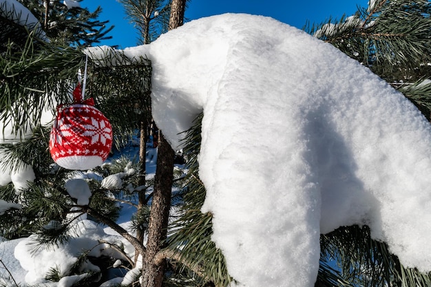 Op een besneeuwde bosdennenboom een decoratief kerstboomspeelgoed