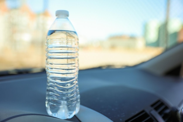 Op een dashboard staat een fles water