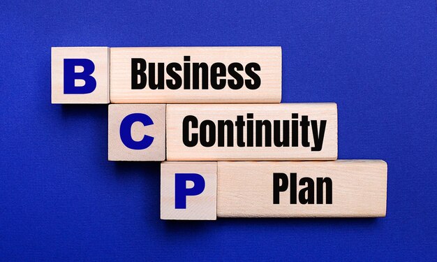 Op een helderblauwe achtergrond, lichte houten blokken en kubussen met de tekst BCP Business Continuity Plan