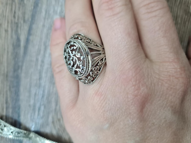 Op een houten tafel ligt een ring met een diamant erop.
