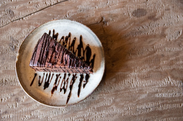 Op een houten tafel staat een chocoladetaart.