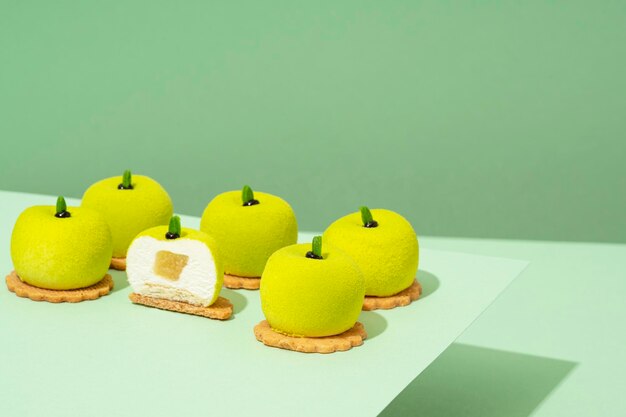 Op een houten tafel staat een schaal met diverse groene donuttraktaties