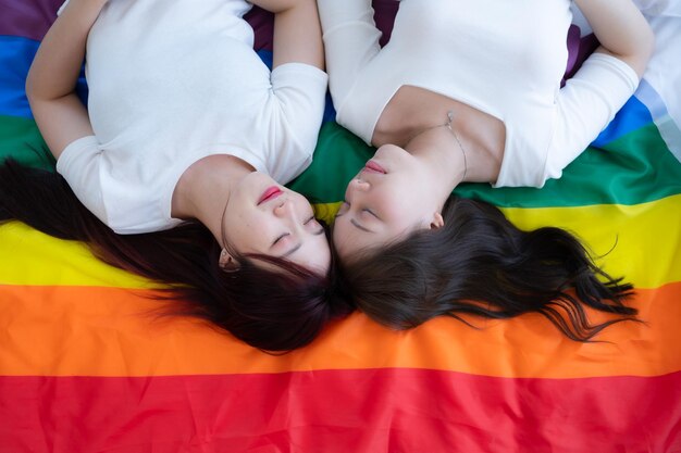 Op een regenboogvlag liggen LGBT-paren gelukkig te kletsen en elkaar te plagen.