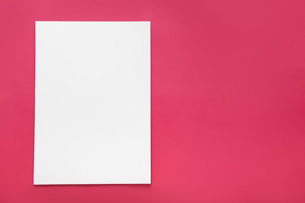 Op een roze achtergrond een wit vel papier bovenkant sjabloon leeg voor ontwerp
