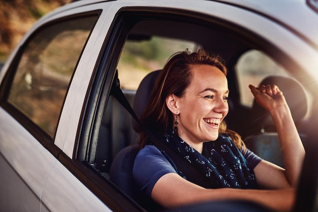 Op een solo roadtrip Bijgesneden opname van een jonge vrouw die in haar auto rijdt