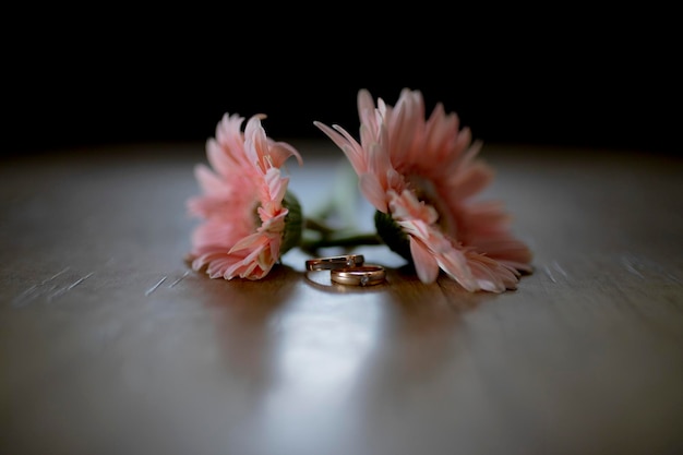 Op een tafel liggen een paar bloemen met een ring erop.