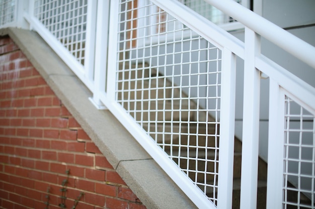 Op een trap wordt een wit draadrooster geplaatst.