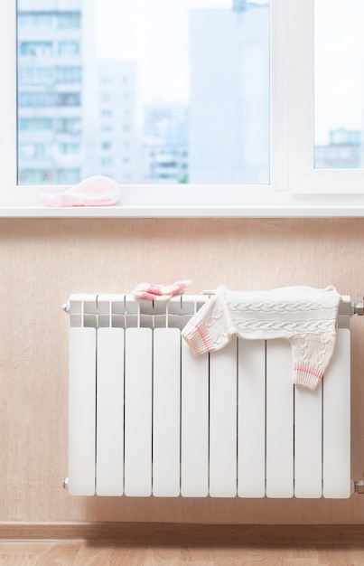 Op een warme radiator drogen kinderkleding op