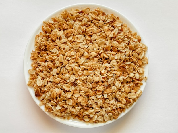 Op een witte geïsoleerde achtergrond granola op bord ontbijtschotel snack Op de foto is een korrel van o