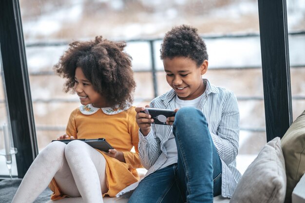 Op internet. twee kinderen die tijd online doorbrengen met hun apparaten