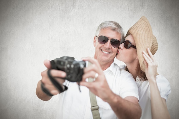 Op vakantie gaand paar dat foto tegen witte achtergrond neemt