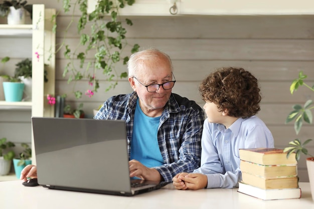 Opa en kleinzoon studeren thuis op de computer terug naar school