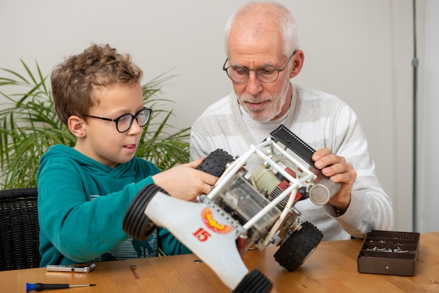 Opa en zoon jongetje repareren van model radiografisch bestuurbare auto thuis