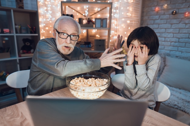 Opa-kleinzoon kijken naar enge film op laptop