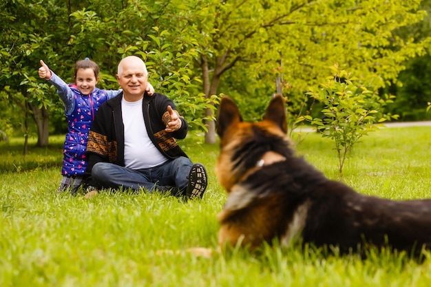 Opa met kleindochter en een hond in de tuin