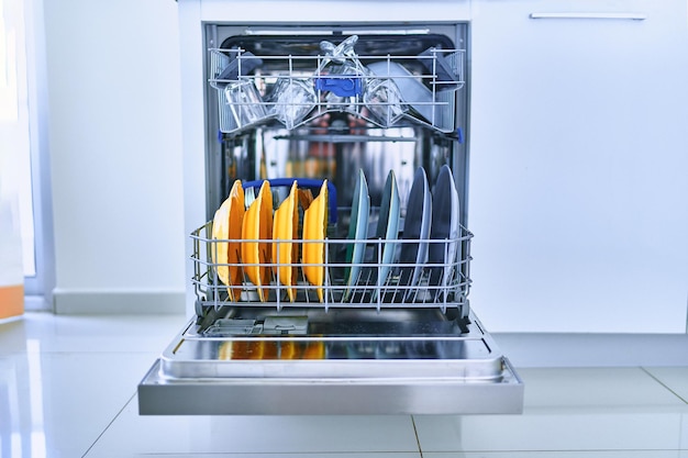 Open afwasmachine met glanzende schone schotels in een witte huiskeuken