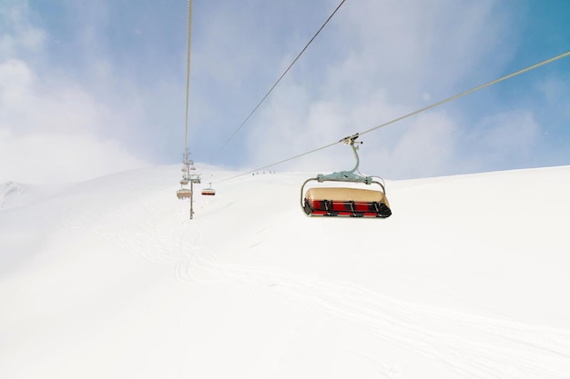 Foto un ascensore all'aperto che va in cima alla montagna per sciare in discesa un giorno di sole circondato da