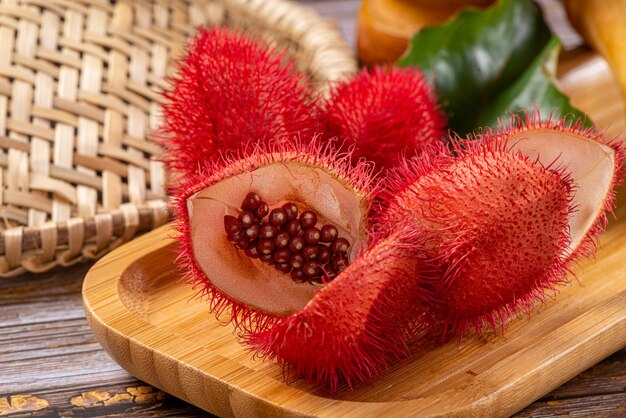 Open annatto with seeds exposed on wooden table.