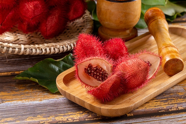 Open annatto with seeds exposed on wooden table.