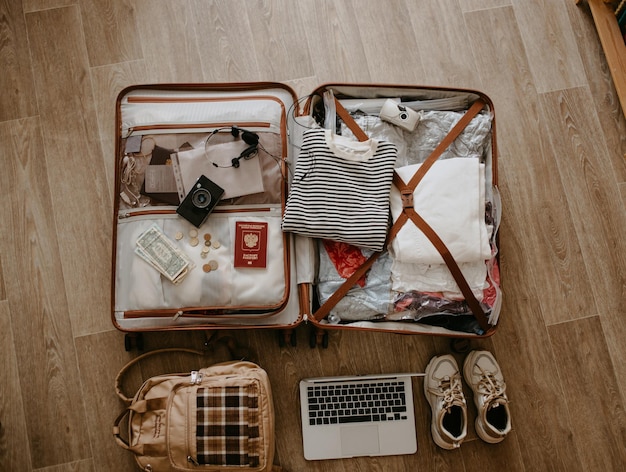open baggage with snickers sweater laptop headphones and passport vintage camera and backpack