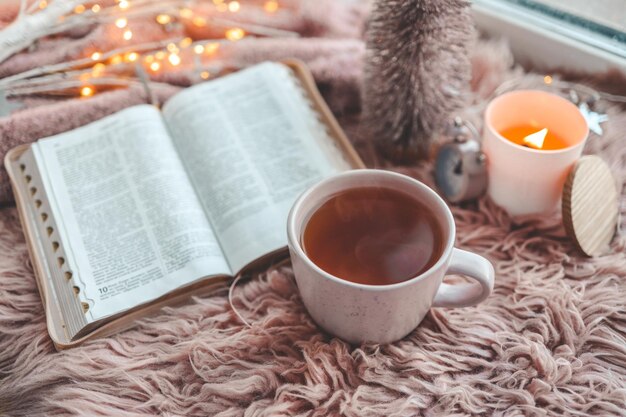 Open bible in cozy pink winter home morning atmosphere