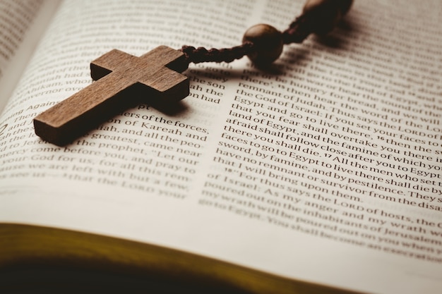 Открытая библия и деревянные четки