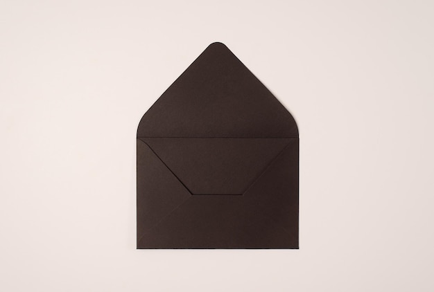 Open black envelope on a light background of a milky color