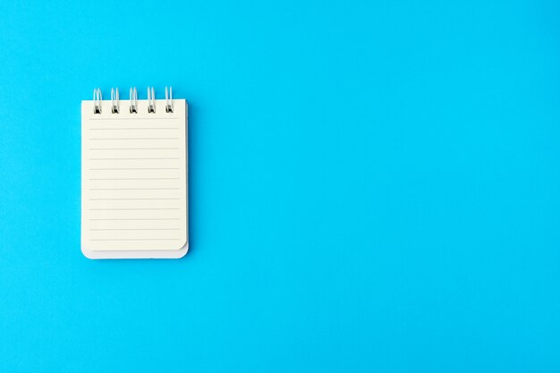 Open blank notebook in line on a blue background