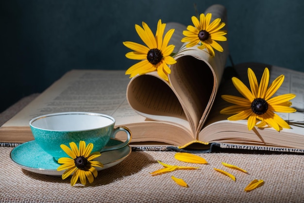 Open boek met bloemen en een kopje thee op tafel