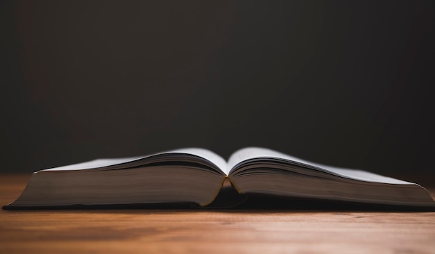 Open boek op een houten tafel op een donkere ondergrond