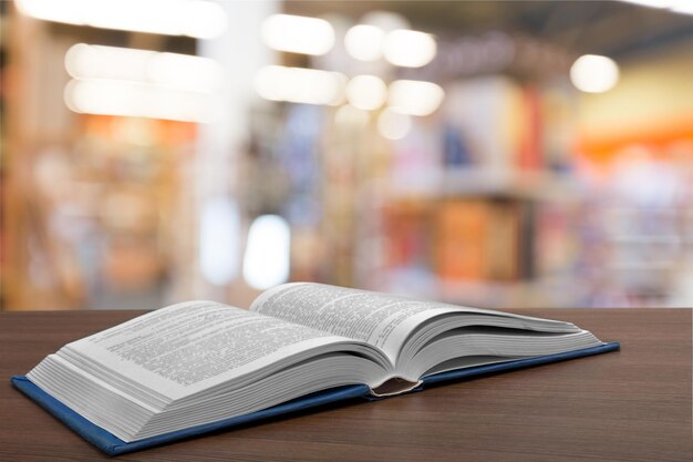 Open boek op oude houten tafel bij bibliotheek achtergrond