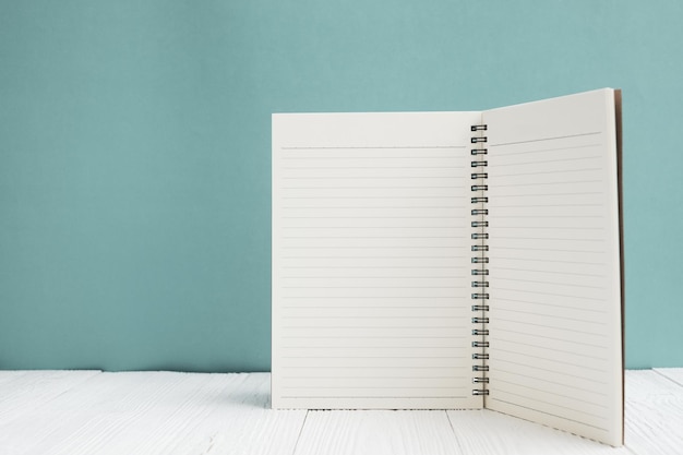 Foto open boek op tafel tegen de muur.