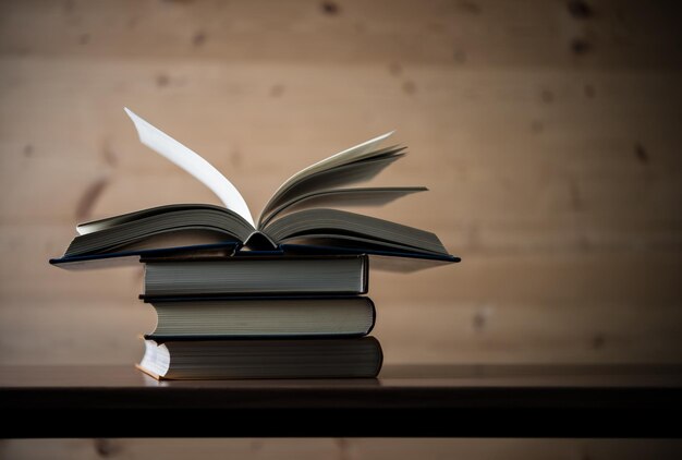 Open boek stapel van hardcover boeken op houten tafel Onderwijs concept Kopieerruimte