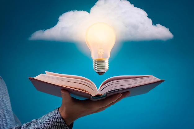Open boek vastgehouden door een hand met een gloeilamp die er boven drijft en kennis en ideeën symboliseert