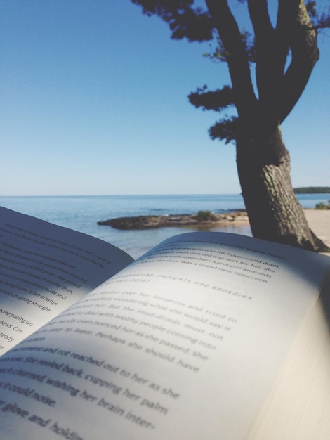 Foto libro aperto sulla spiaggia contro un cielo limpido