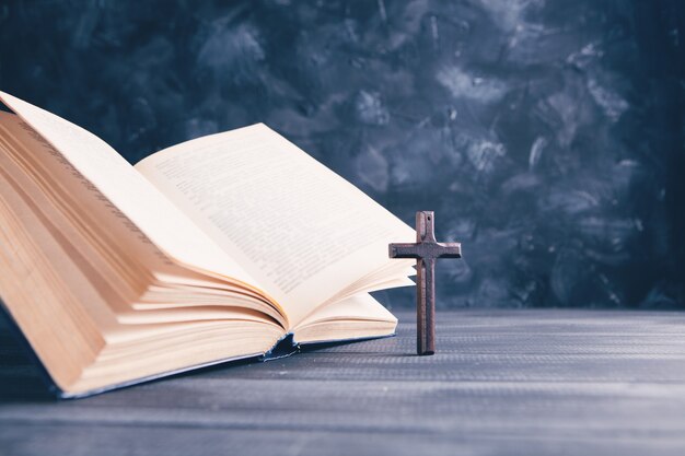 Open book and cross on the table