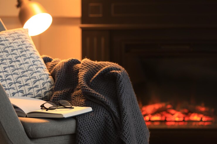 Photo open book glasses and plaid on armchair near fireplace at home space for text cozy atmosphere