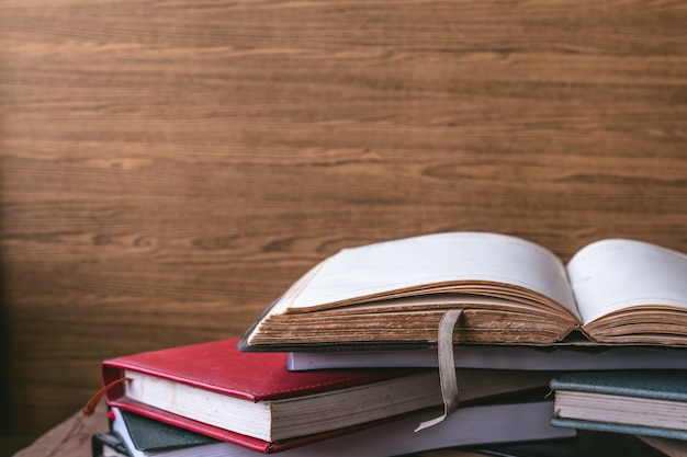 Libro aperto, libri con copertina rigida su fondo di legno della parete. spazio libero per il testo