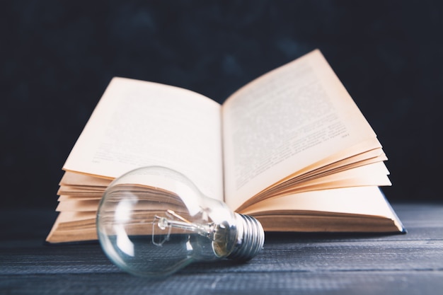 An open book and a light bulb on the table