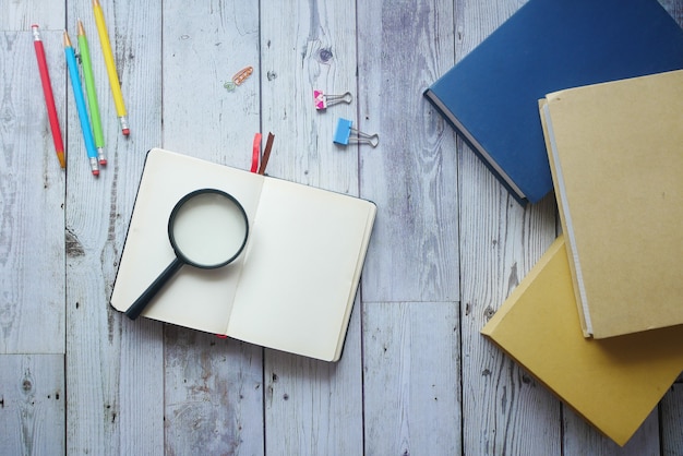 Open book and magnifying glass on table