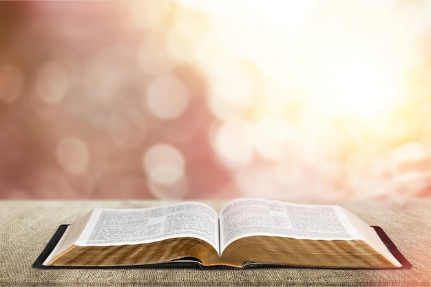 Open book on old wooden table.