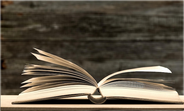 Open book on old wooden table.