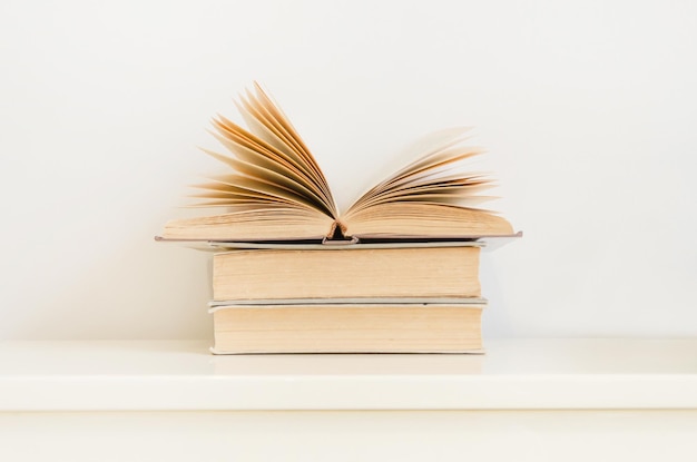 Open book on stack of vintage hardback books on table concept of education reading back to school